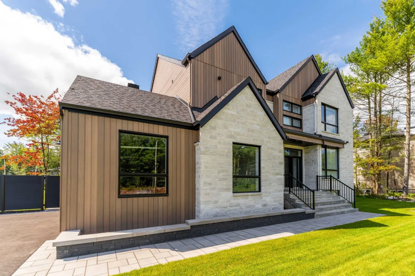 Home clad in MAC Metal wood-look steel siding with black window trim and stone accent